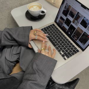 Emprendedora creando su marca de moda online con laptop y telas